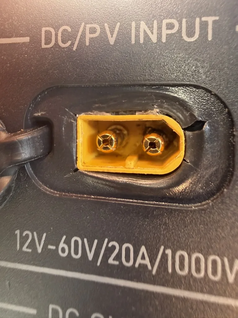 Close-up of the scorched DC/PV input port on the BLUETTI Elite 200 V2 with burn marks around the connector