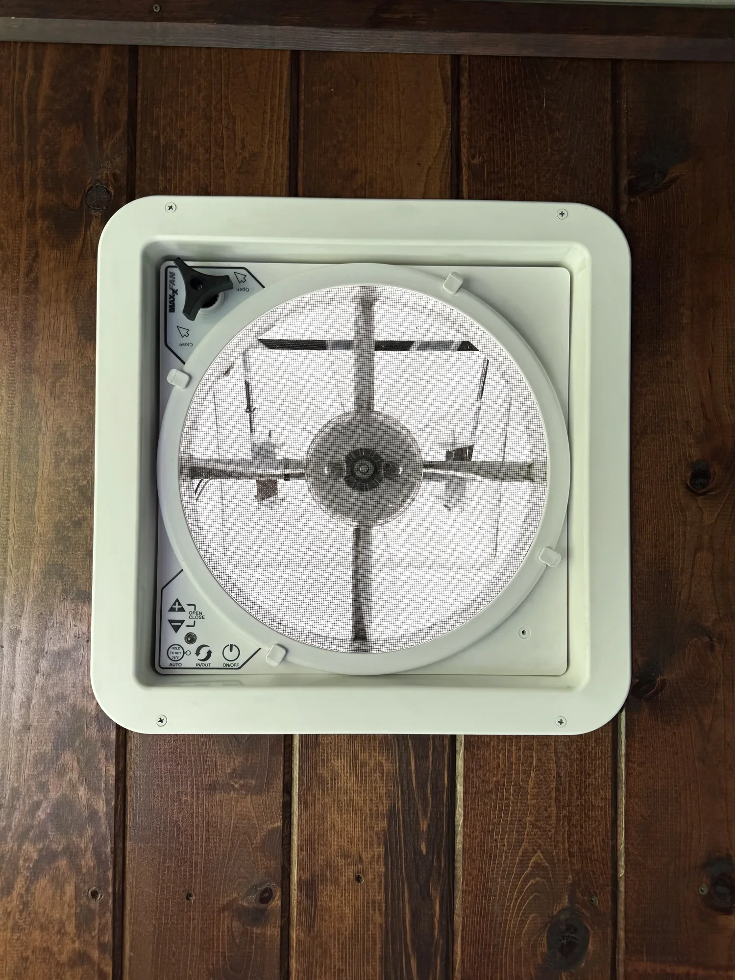 Ceiling control panel of the MaxxFan Deluxe 7500K, showing the speed keypad, open and close arrows, thermostat, in-out reverse and power controls